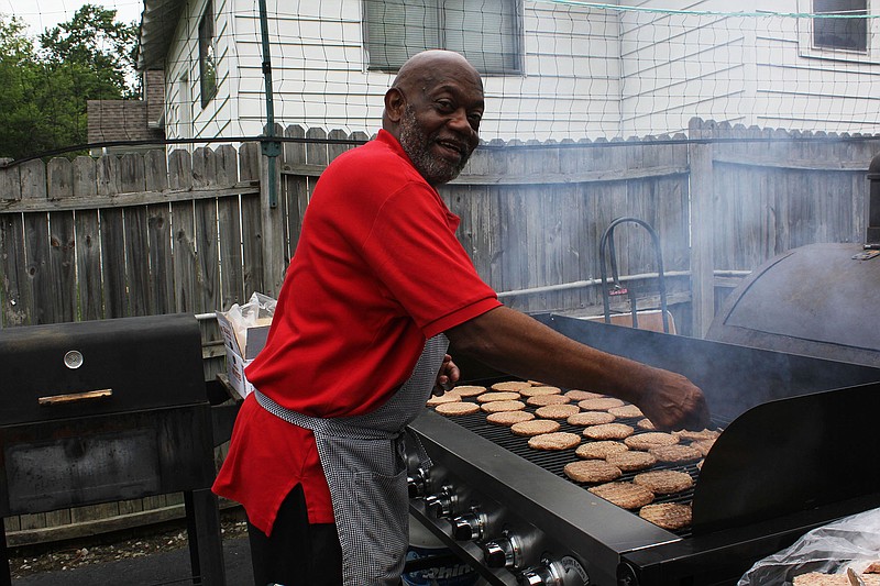 Otis Rumph grills patties during his 11th annual "Out of School" party for neighborhood children. (Contributed photo)