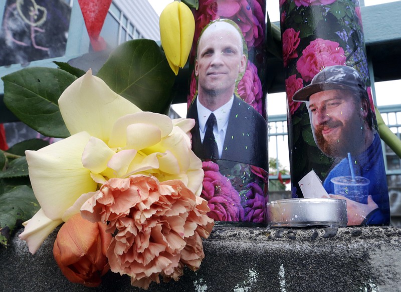 
              In this Wednesday, May 31, 2017 photo, candles with photos of Taliesin Namkai-Meche, right, and Ricky Best on them sit at a memorial for the two men in Portland, Ore. Jeremy Christian, accused of stabbing the two men to death who tried to stop him from hurling anti-Muslim insults at young women on a Portland light rail train May 26, 2017, came from a stable family and was a rambunctious teenager who spiraled out of control as he entered his teenage years, according to court records and acquaintances. (AP Photo/Don Ryan)
            