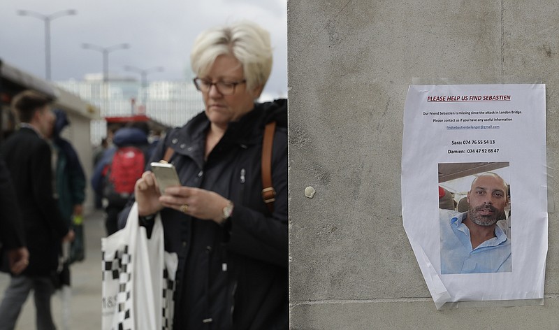 
              A woman walks by a poster of a missing man in the London Bridge area of London on Tuesday, June 6, 2017. A new search was underway Tuesday in a neighborhood near the home of two of the London Bridge attackers, hours after police said they had freed everyone detained in the wake of the Saturday evening rampage that left several dead and dozens wounded. (AP Photo/Matt Dunham)
            