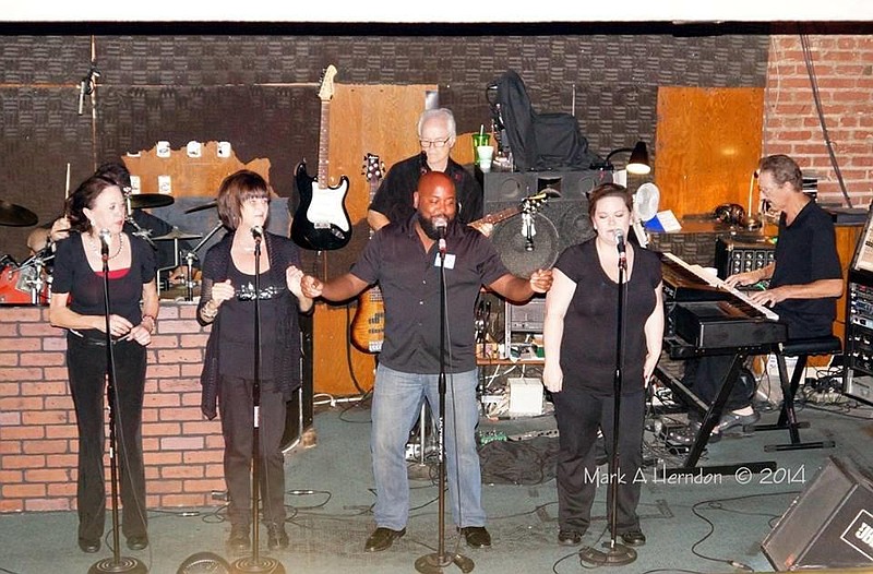 Singing on the stage at the old Station House are, from left, Laquada Camp, Cheryl Strickland, Landis Batts and Amanda Jones. On guitar is Tim Strickland and Doyle Wright on keyboards.