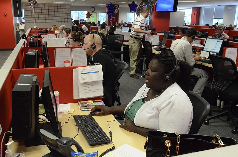 Bart Hohimer, left, and Vaneshia Adair, right, work in the call center at HomeServe in Brainerd. The company, providers of insurance plans for exterior and interior home repair, is experiencing rapid growth and plans to hire 100 more workers. 