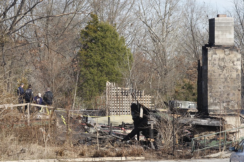 Investigators with the East Ridge police and fire departments talk Friday, Dec. 27, 2013, at the remains of the former Hungry Fisherman restaurant which burned early Christmas morning. Authorities said that human remains were found in the ashes of the fire.