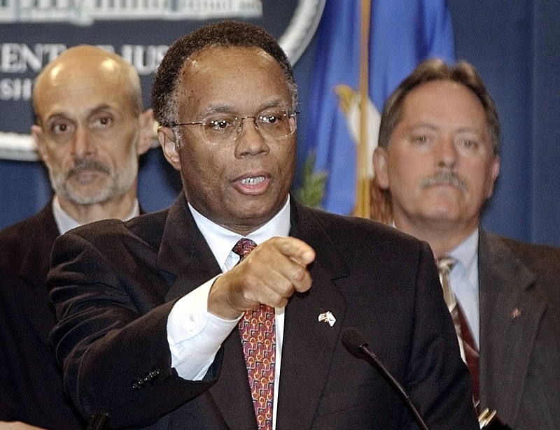 In this Oct. 17, 2002 file photo Deputy Attorney General Larry Thompson, center, talks with reporters in Washington, United States. At left, Michael Chertoff, then head of the Justice Department's Criminal Division, and FBI Deputy Director Bruce Gebhardt, right, listen. Thompson the independent monitor overseeing Volkswagen's efforts to prevent a repeat of its emissions scandal says he has a "broad mandate" to review the company's practices and that his initial impression is that VW is making a serious effort to reform. (AP Photo/Toyokazu Kosugi, File)
