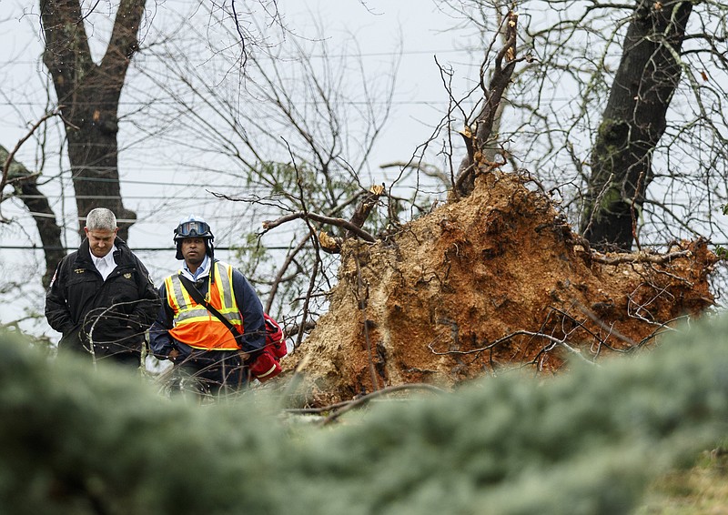 Emergency workers examine a downed tree at a home on Westwood Avenue on Wednesday, March 1, 2017, in Chattanooga, Tenn. Severe storms swept through the region Wednesday afternoon.