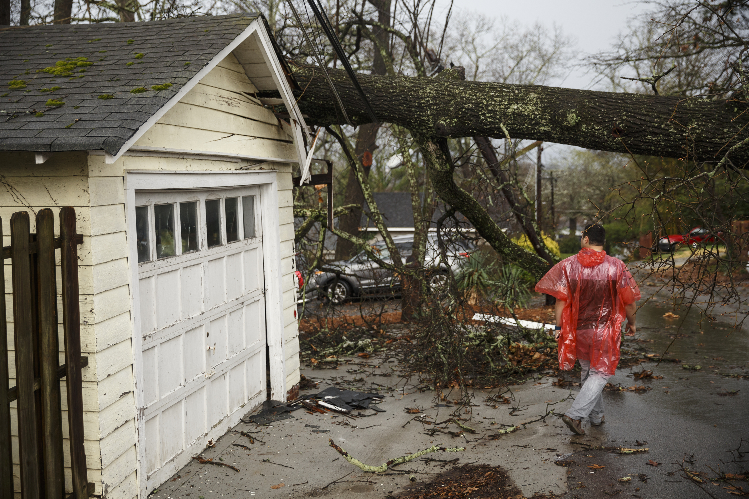 Isam Ghazi examines a downed tree on a garage between Westwood Avenue and Highland Drive on Wednesday, March 1, 2017, in Chattanooga, Tenn. Severe storms swept through the region Wednesday afternoon.