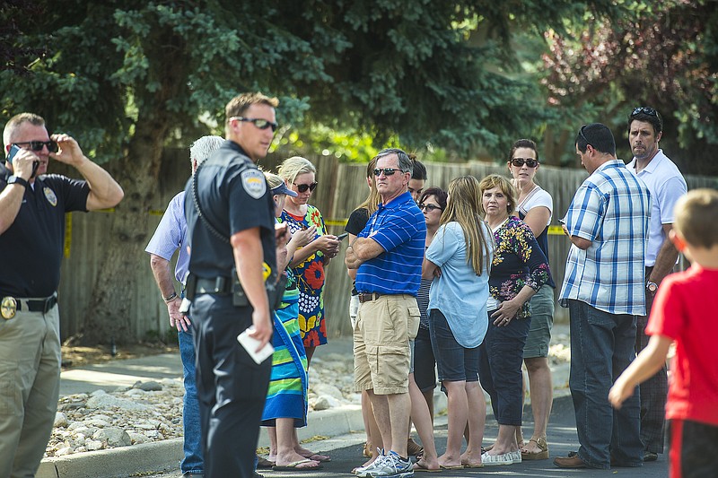 
              Community members look on as police officers investigate the scene of a shooting in Sandy, Utah, Tuesday, June 6, 2017. Utah police say the shooter in a suburban Salt Lake City neighborhood is among several people who died in the incident and two others injured were children. The shooting took place on a neighborhood street in the suburb of Sandy, about 20 miles southeast of Salt Lake City. (Chris Detrick/The Salt Lake Tribune via AP)
            