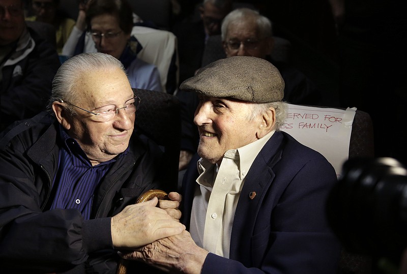 
              In this Wednesday, June 7, 2017 photo, Holocaust survivors Israel Arbeiter, left, and Steve Ross, right, greet one another at a theater before the premier of the film "Etched in Glass: The Legacy of Steve Ross," in West Newton, Mass. The film recounts Steve Ross' five years spent in Nazi concentration camps as a child and his decadeslong search for the American soldier who gave him a U.S. flag handkerchief during the liberation of the Dachau concentration camp in Germany. (AP Photo/Steven Senne)
            