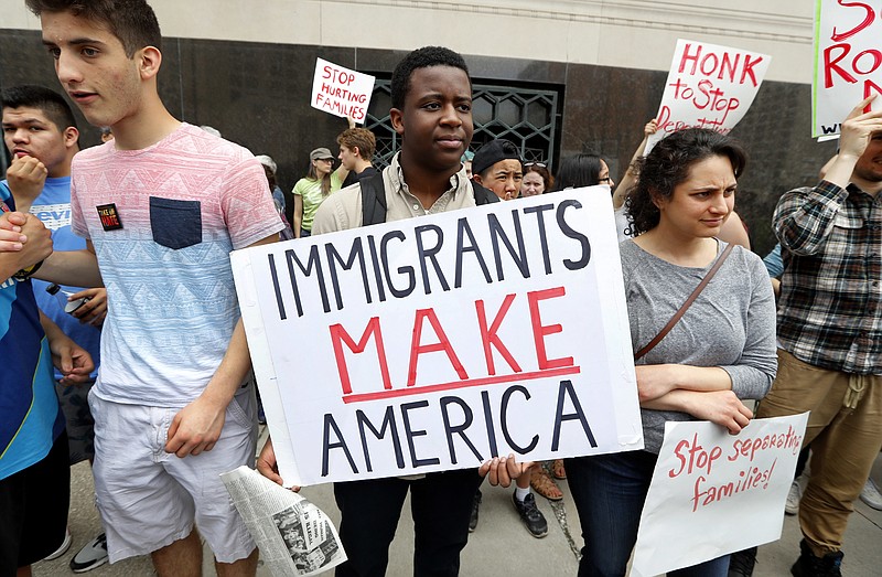 
              FILE - In this May 16, 2017, file photo, Torianto Johnson, a freshman at Pioneer High School in Ann Arbor, Mich., holds a sign supporting immigrants during a rally outside a federal courthouse in Detroit. For years, immigrants have checked in regularly with federal deportation agents to show they've been following the country's laws even though they have been ordered to leave. Now, in cases spanning from Michigan to California, many of those who have exhausted their legal options are being told their time here is up. (AP Photo/Paul Sancya, File)
            