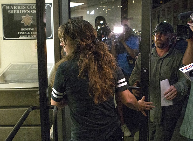 Chauna Thompson, foreground, and her husband, Terry Thompson, right, turn themselves in to the Harris County Sheriff's Office on Thursday, June 8, 2017, in Houston. Thompson, a Harris County Sheriff's deputy, and her husband were indicted on murder charges in the death of a man they restrained during a late night confrontation outside of a restaurant while she was off duty. (Brett Coomer/Houston Chronicle via AP)