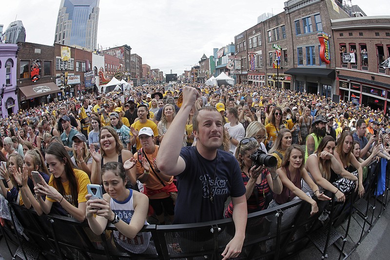 
              Fans watch a pre-game concert as they wait to watch Game 4 of the NHL hockey Stanley Cup Finals between the Nashville Predators and the Pittsburgh Penguins on Broadway Street in Nashville, Tenn., Monday, June 5, 2017. (AP Photo/Mark Humphrey)
            