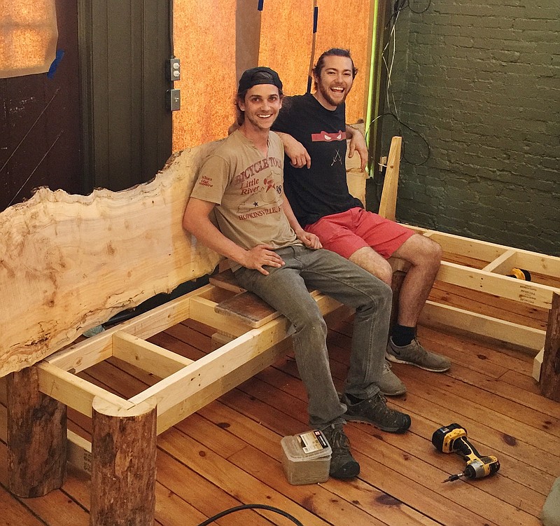 Jacob Mundy, left, and Brett Allen sit on an unfinished bench in Basecamp Restaurant and Bar on Frazier Avenue. The pair are still finishing work on the inside of the restaurant in preparation for opening to the public the week of June 19.
