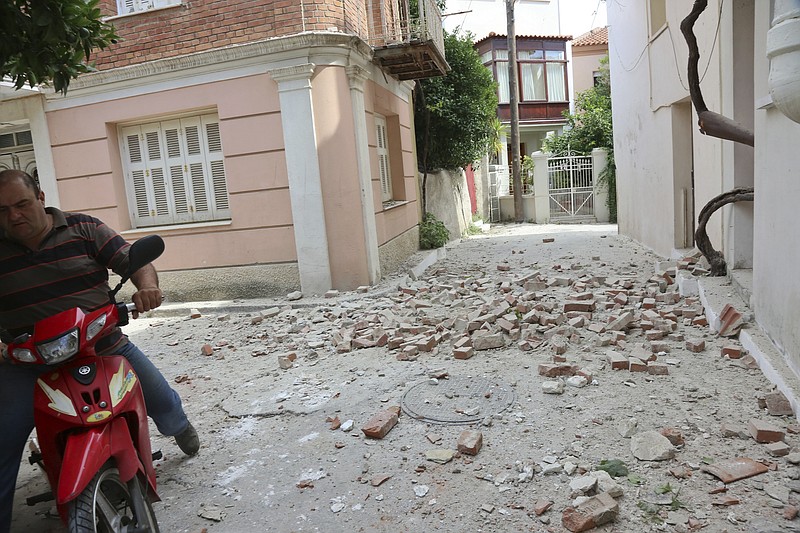 
              A man with his motorcycle passes next to a damaged house after an earthquake in the village of Plomari on the northeastern Greek island of Lesbos, Monday, June 12, 2017. A Turkish government agency says an earthquake with a preliminary magnitude of 6.2 has shaken western Turkey. The Greek island of Lesbos has also been rattled. (Manolis Lagoutaris/InTime News via AP)
            