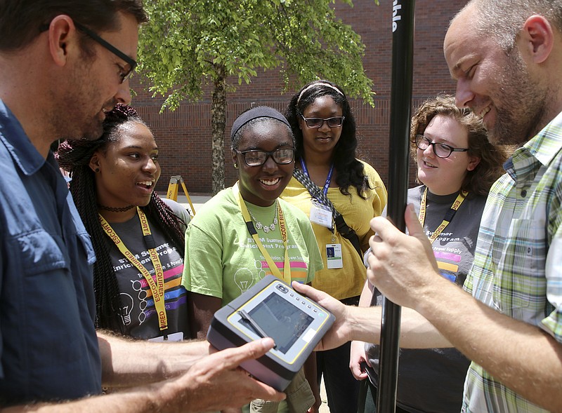 Tennessee Valley Authority land surveyors Eric Donan, left, and Jeremiah Mcmichen, right, demonstrate GPS surveying equipment to Jada Brown, second from left, Zapouria Wadley, Maya Johnson and Sarah Lewis outside of the TVA headquarters on Tuesday, June 13, in Chattanooga, Tenn. Brown, from Chattanooga School for the Arts and Sciences, Wadley, from Chattanooga Girls Leadership Academy, and Lewis, from Chattanooga Center for Creative Arts, are part of the STEM summer enrichment program. Johnson is a participant in the CADnet school-to-work program.