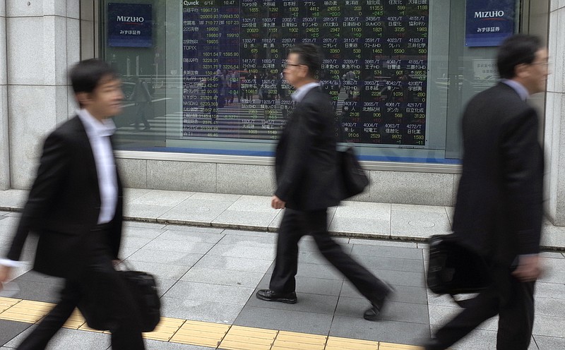 
              People walk past an electronic stock board showing Japan's Nikkei 225 index at a securities firm in Tokyo, Wednesday, June 14, 2017. Asian stocks were mixed Wednesday following Wall Street’s tech-driven rise as investors waited for word from the U.S. Federal Reserve on a possible interest rate hike. (AP Photo/Shuji Kajiyama)
            