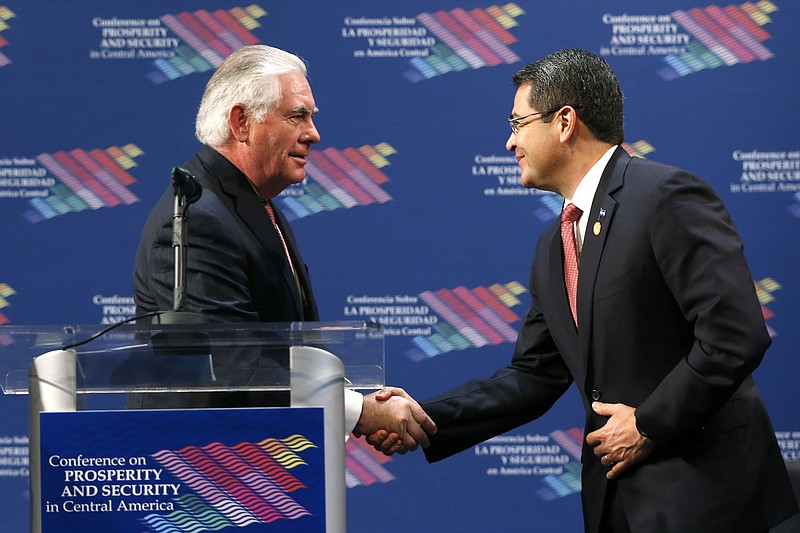 
              Secretary of State Rex Tillerson, left, shakes hands with the President of Honduras Juan Orlando Hernandez, right, during a conference on Prosperity and Security in Central America, Thursday, June 15, 2017, in Miami. (AP Photo/Wilfredo Lee, Pool)
            