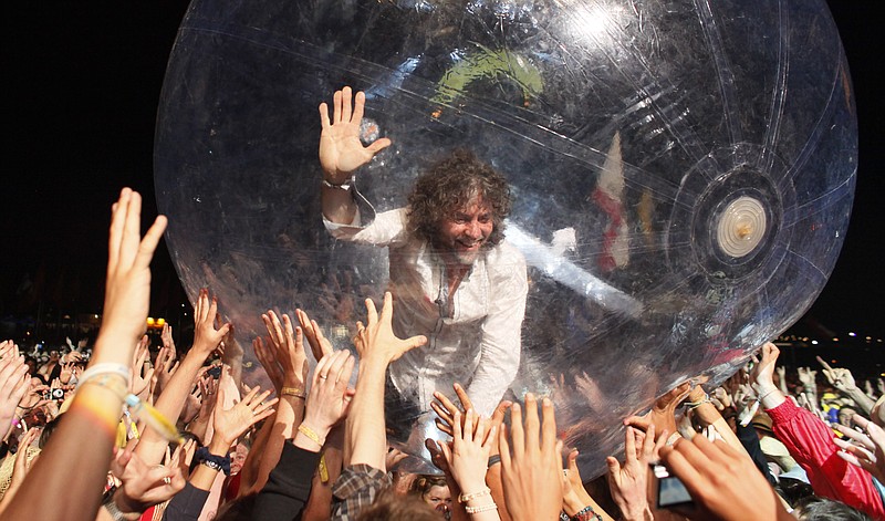 U.S. band The Flaming Lips, frontman Wayne Coyne takes a trip across the heads of the crowd inside a plastic bubble, as the band performs at Glastonbury Festival, in Glastonbury, England,  Friday, June 25, 2010. The Festival celebrates its 40th anniversary this year. (AP Photo/Jim Ross)