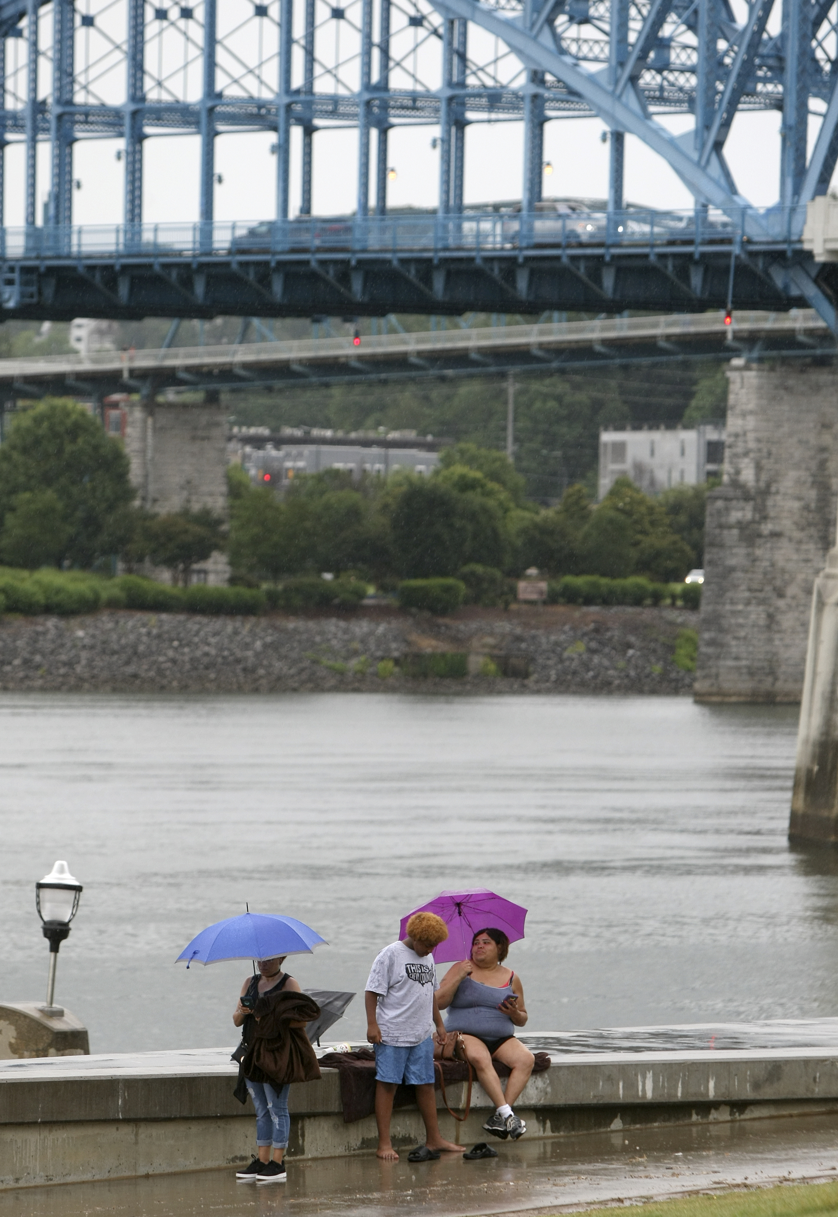 Peggy Burse, left, Anthony Johnson and Chandlin Johnson mingle along the riverwalk during the seventh night of the Riverbend Festival at Ross's Landing on Thursday, June 15, in Chattanooga, Tenn. Morris Day and The Time with Cameo headlined the evening.