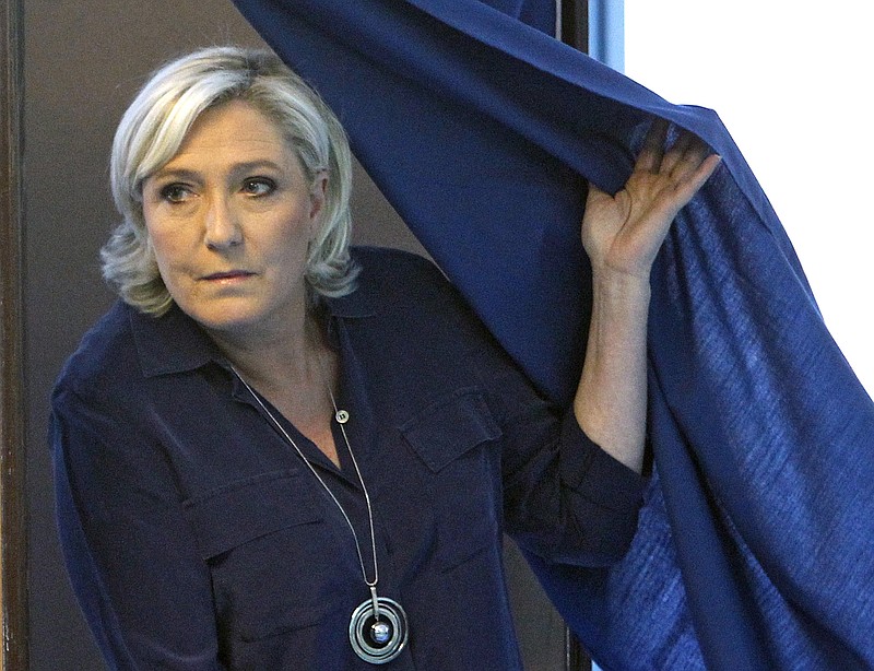 
              FILE - In this Sunday, June 11, 2017 file photo, French far-right candidate, Marine Le Pen exits a voting booth before casting her ballot as part of the first round of the French parliamentary elections in Henin Beaumont, Northern France. Marine Le Pen, who wanted to lock the doors of France to migrants, Muslims, the euro currency and the European Union,  but now her far-right party is expected to get only a handful of seats in France's parliament. (AP Photo/Michel Spingler, FILE)
            