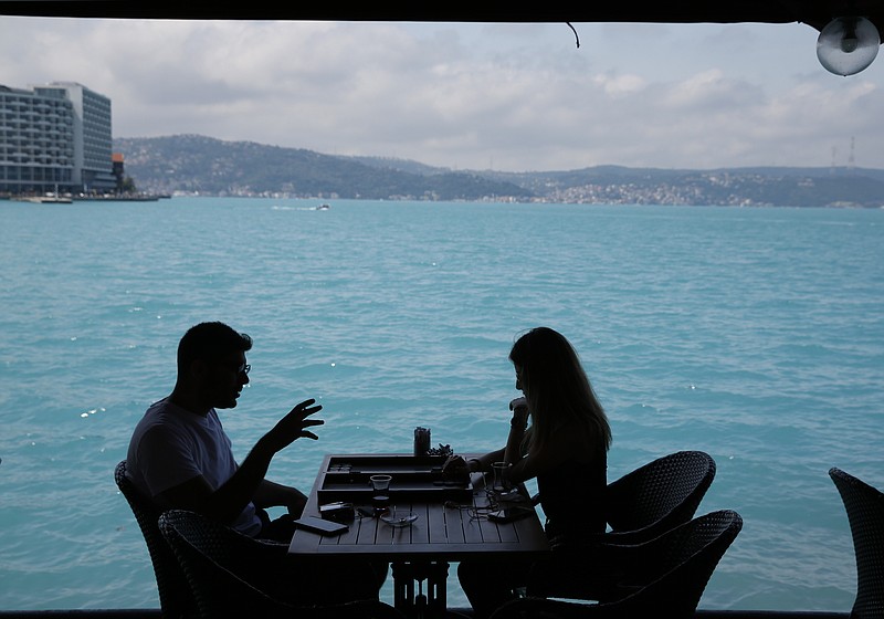 
              People play backgammon in a coffee shop by Istanbul's Bosphorus Strait, Wednesday, June 14, 2017. Turkish media report a significant part of the Black Sea and the Bosphorus has turned turquoise due to phytoplankton.(AP Photo/Lefteris Pitarakis)
            