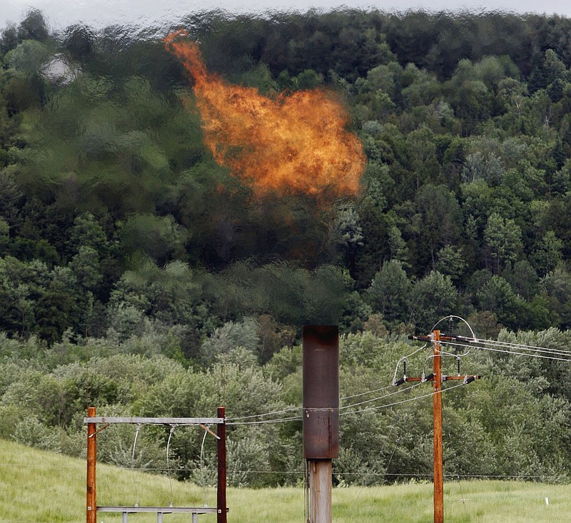 
              FILE - In this June 15, 2005 file photo, flames from methane burning at the landfill in Coventry, Vt. The Trump administration is delaying two Obama-era regulations aimed at restricting harmful methane emissions from oil and gas production.  (AP Photo/Toby Talbot, File)
            