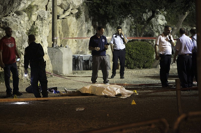 
              Israeli police stand around a body of a Palestinian in Jerusalem, Friday, June 16, 2017. Three Palestinians armed with an automatic weapon and knives attacked Israeli officers on duty near Jerusalem's Old City in twin attacks at two locations Friday evening, critically wounding one before they were shot and killed. (AP Photo/Mahmoud Illean)
            