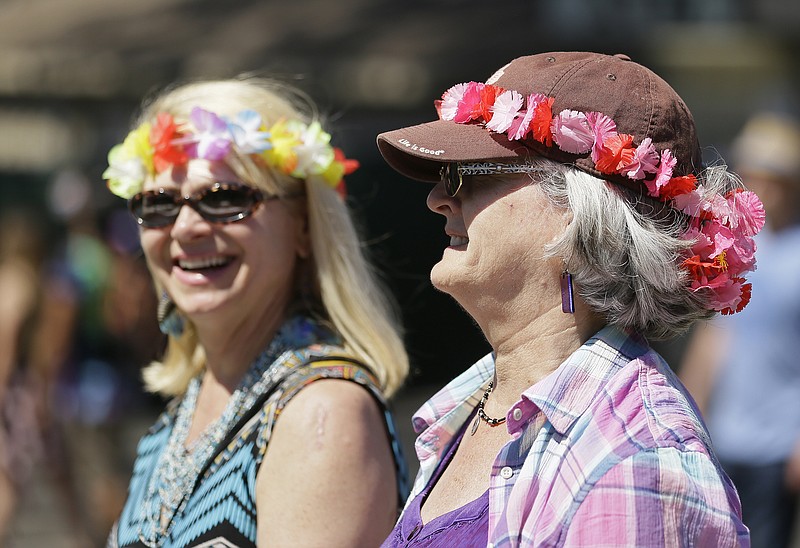 
              A pair of women walk with flowers in their hair during the Monterey International Pop Festival Friday, June 16, 2017, in Monterey, Calif. The festival turned 50 on Friday and celebrated its anniversary by kicking off another three-day concert that's bringing back a few acts from half a century ago. In 1967 the festival was the centerpiece of the "Summer of Love." (AP Photo/Eric Risberg)
            