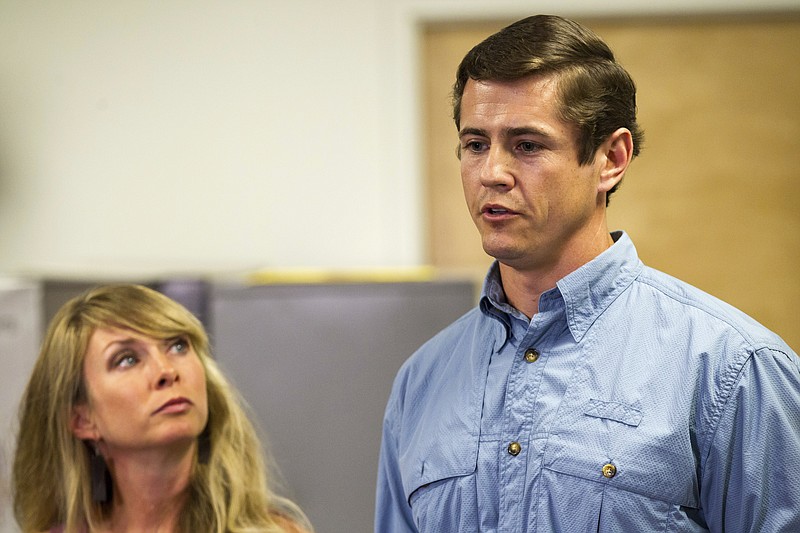 
              Patrick Hale, the man credited by law enforcement with forcing the surrender of two Georgia prison escapees, speaks to reporters in Murfreesboro, Tenn., on Friday, June 16, 2017, while his wife, Danielle, looks on. Hale said he was carrying a loaded weapon but never pulled it out when the two inmates got face down on his concrete driveway without saying a word. (AP Photo/Erik Schelzig)
            