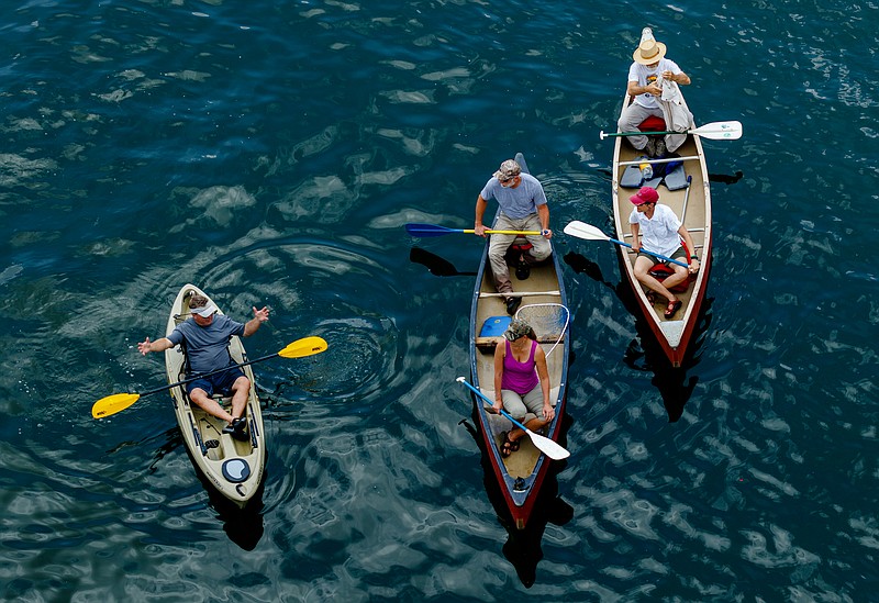 Volunteers in canoes prepare to work as duck wranglers during the Great Kiwanis Duck Race on the Tennessee River on Saturday, June 17, 2017, in Chattanooga, Tenn. Thousands of rubber ducks were dropped from the Walnut Street Bridge to drift with the current downstream in a race to the finish, and proceeds for entries benefitted the Children's Advocacy Center of Hamilton County.