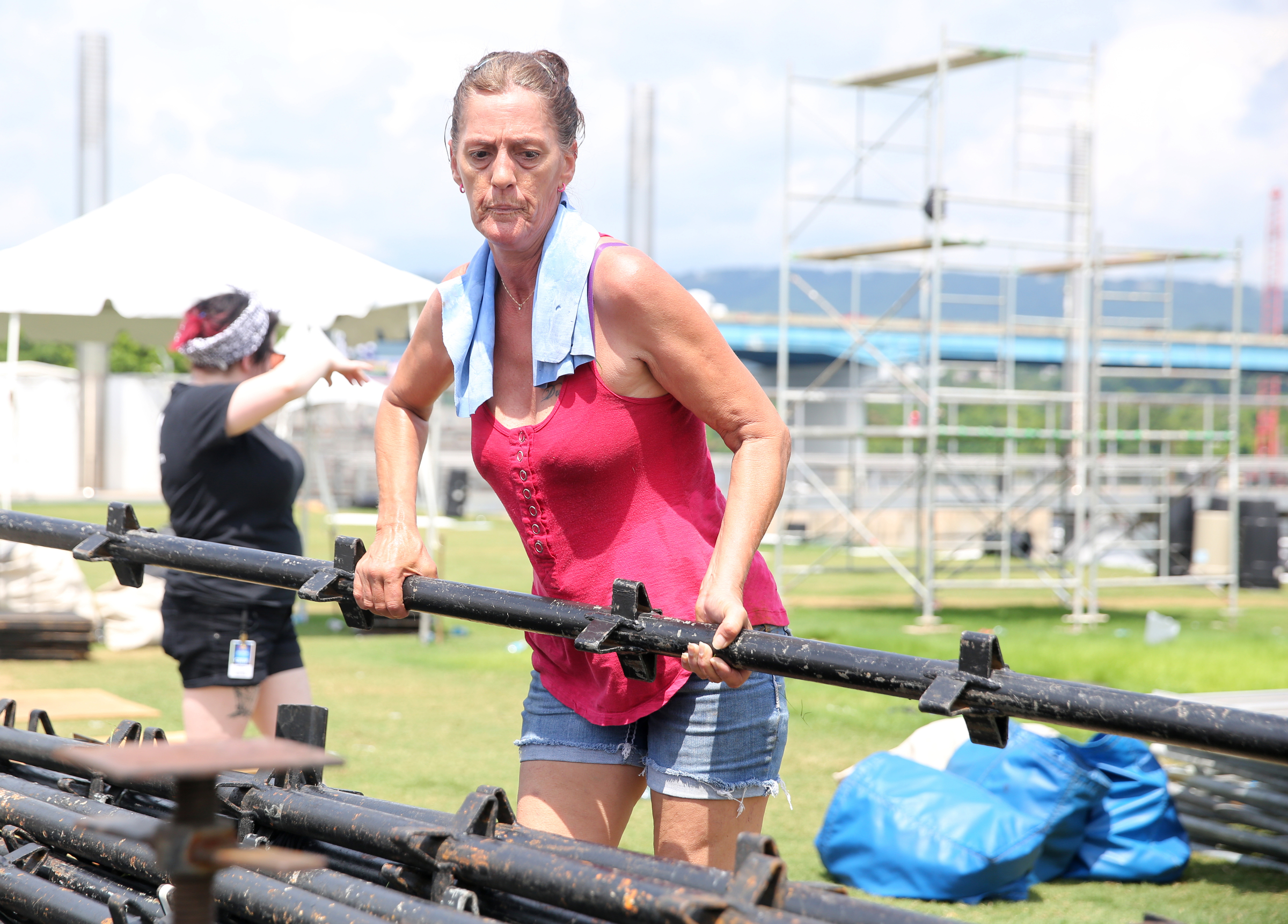 Angela Griffith helps stack stands at Ross's Landing in Chattanooga, Tenn., Sunday, June 18, 2017. After more than a week of performances, Riverbend Festival 2017 is over. Griffith's dad is the stage manager for the Coke Stage during Riverbend Festival.