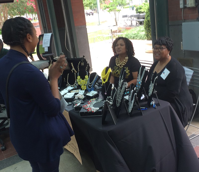 Betty Carolyn Jackson, seated left, and her mother, Sandra Everett, display TraciLynn jewelry during the first day of the weeklong Diversify celebration in Miller Plaza.