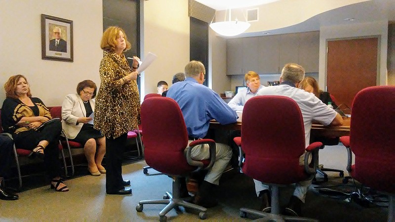 Helen Burns Sharp, standing, raises questions about the Chattanooga Downtown Redevelopment Corporation's sale of the city-owned property under Walnut Commons to the apartment building's owners at a CDRC meeting in 2017.