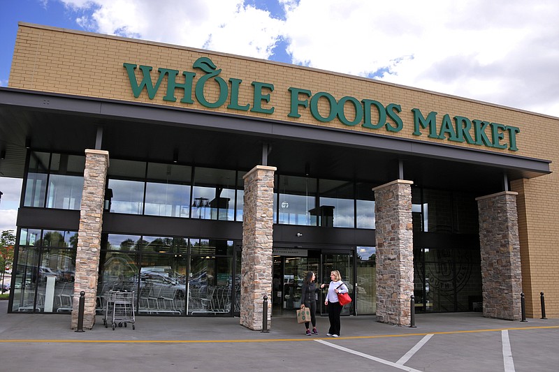 In this May 3, 2017, photo, people stand outside a Whole Foods Market in Upper Saint Clair, Pa. Amazon’s planned $13.7 billion acquisition of Whole Foods signals a massive bet that people will opt more for the convenience of online orders and delivery or in-store pickup, putting even more pressure on the already highly competitive industry. (AP Photo/Gene J. Puskar)