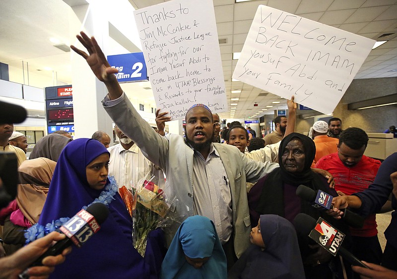 
              Imam Yussuf Abdi, center, addresses his family and friends  Sunday, June 18, 2017, after arriving at Salt Lake City International Airport. Abdi, a Utah Muslim leader barred from flying to the U.S. last week finally returned home. Abdi and his attorneys believe his name was on a government no-fly list and that's why he was blocked from returning to the U.S. from Kenya. Abdi was attempting to bring his wife and children to the U.S. but was blocked last week from boarding flights in Kenya and Los Angeles. (AP Photo/Rick Bowmer)
            