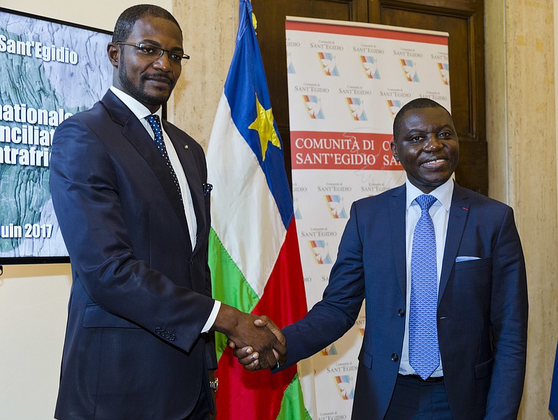 
              Foreign Minister of the Central African Republic Charles Armel Doubane, right, and Armel Mingatoloum Sayo head of the Revolution and Justice militia shake hands after signing the Political Agreement for Peace in the Central African Republic at the Sant'Egidio headquarters in Rome, Monday, June 19, 2017. Members of 13 Central African Republic's militant groups signed a preliminary agreement to stop the civil war, reaffirm the unity of the country, and the respect of human and civil rights. (AP Photo/Domenico Stinellis)
            