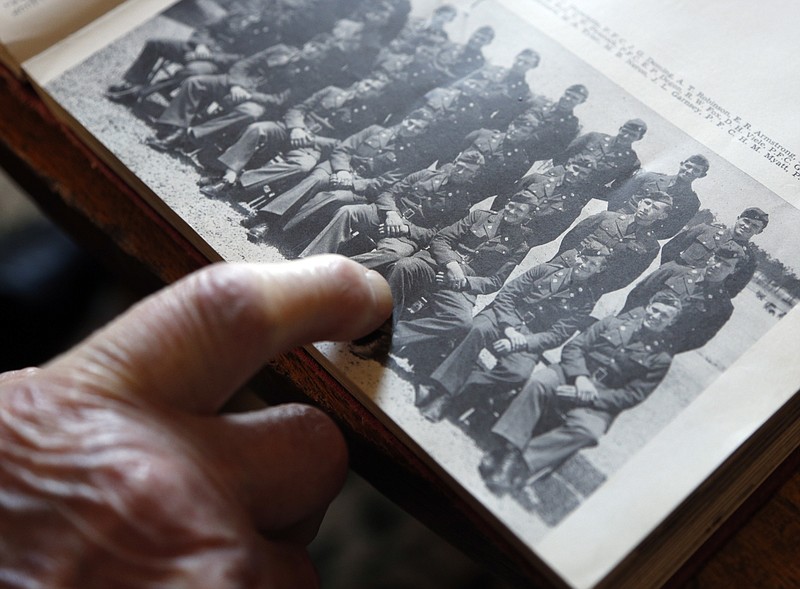 
              FILE - In this May 8, 2014 file photo, World War II veteran Arthur Robinson points to himself in a 1940 photograph of the Army's 27th Infantry Division, while visiting the New York State Military Museum in Saratoga Springs, N.Y. A new book by a Texas-based military history writer tells the story of one of World War II's bloodiest battles and the role a New York National Guard unit played in the fighting. (AP Photo/Mike Groll, File)
            