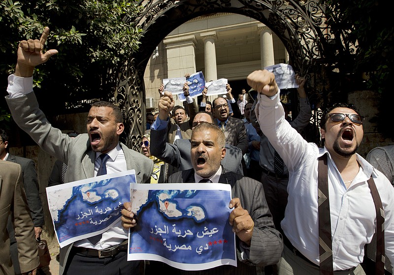 
              FILE - In this Tuesday, June 13, 2017, file photo, dozens of lawyers shout slogans during a protest against the accord to hand over control of two strategic Red Sea islands, Tiran and Sanafir, to Saudi Arabia in front of the lawyers syndicate in Cairo. The tempestuous parliament approval of a deal transferring two Red Sea islands to Saudi Arabia is putting Egypt’s government at odds with the judiciary and providing the country’s battered opposition a nationalist cause to whip up at a time of growing economic distress.  Arabic on the Red Sea map reads, " bread.. freedom, the islands are Egyptians". (AP Photo/Amr Nabil)
            