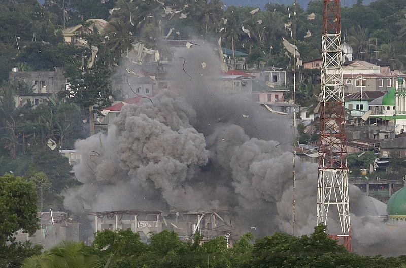
              FILE - In this Friday, June 9, 2017 file photo, debris and smoke rises after a Philippine Air Force fighter jets bombed suspected locations of Muslim militants, in Marawi city, southern Philippines. Southeast Asia’s jihadis who fought for the Islamic State in Iraq and Syria now have a different battle closer to home in southern Philippines. It’s a scenario raising significant alarm in Washington. The recent assault by IS-aligned fighters on the Philippine city of Marawi has left almost 300 people dead, exposing the shortcomings of local security forces and the extremist group’s spreading reach. (AP Photo/Aaron Favila, File)
            