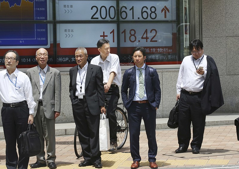 
              People stand in front of an electronic stock board of a securities firm in Tokyo, Monday, June 19, 2017.  Asian shares were higher in subdued trading Monday, after Wall Street ended the week barely higher as Amazon's purchase of Whole Foods sent some retailer stocks downward.(AP Photo/Koji Sasahara)
            