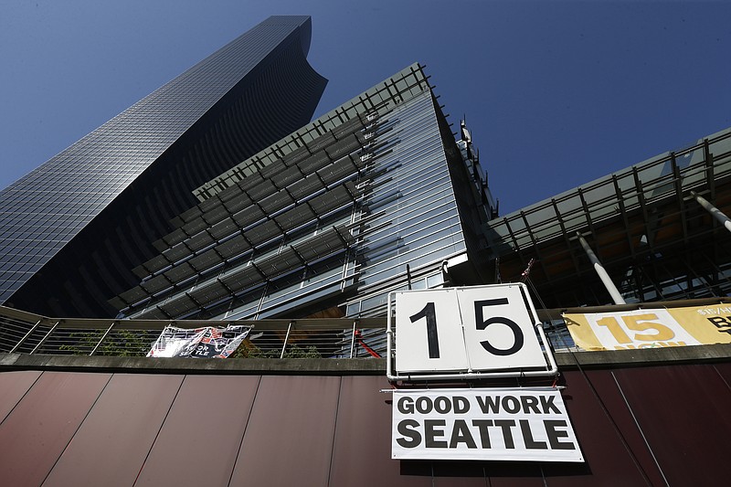 
              FILE - In this June 2, 2014, file photo, a sign that reads "15 Good Work Seattle" is displayed below Seattle City Hall, right, and the Columbia Center building, left, after the Seattle City Council passed a $15 minimum wage measure. A new study says Seattle's $15-an-hour minimum wage law has boosted pay for restaurant industry workers without costing jobs. The report, from the University of California at Berkeley, is certain to add to the debate as activists around the country push for increases in local, state and federal minimum wages. (AP Photo/Ted S. Warren, File)
            