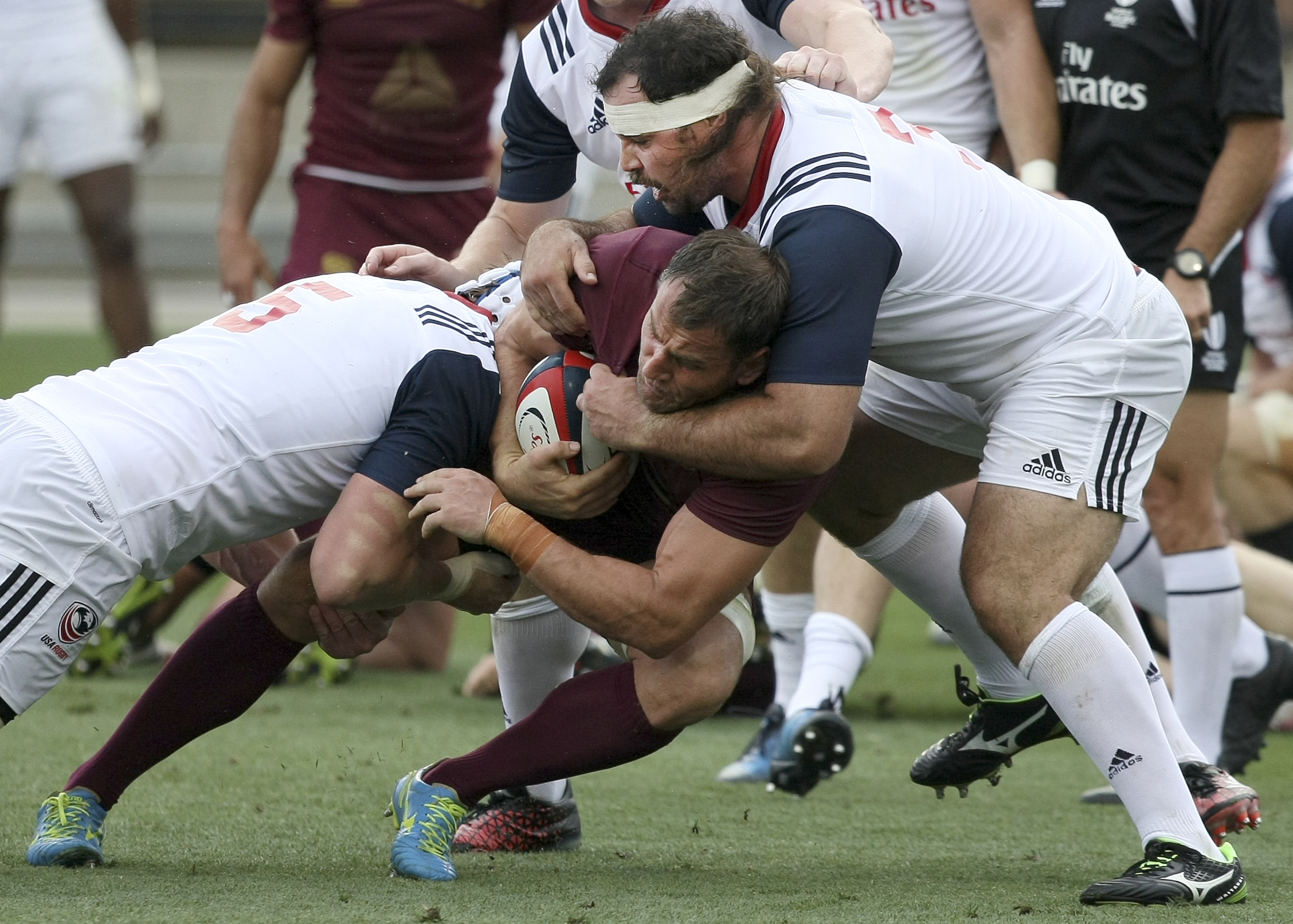 USA's Ben Landry (5) and Chris Baumann (3) work to bring down Georgia's Giorgi Nemsadze during an international rugby test match at Kennesaw State University's Fifth Third Bank Stadium on Saturday, June 17, in Kennesaw, Ga.