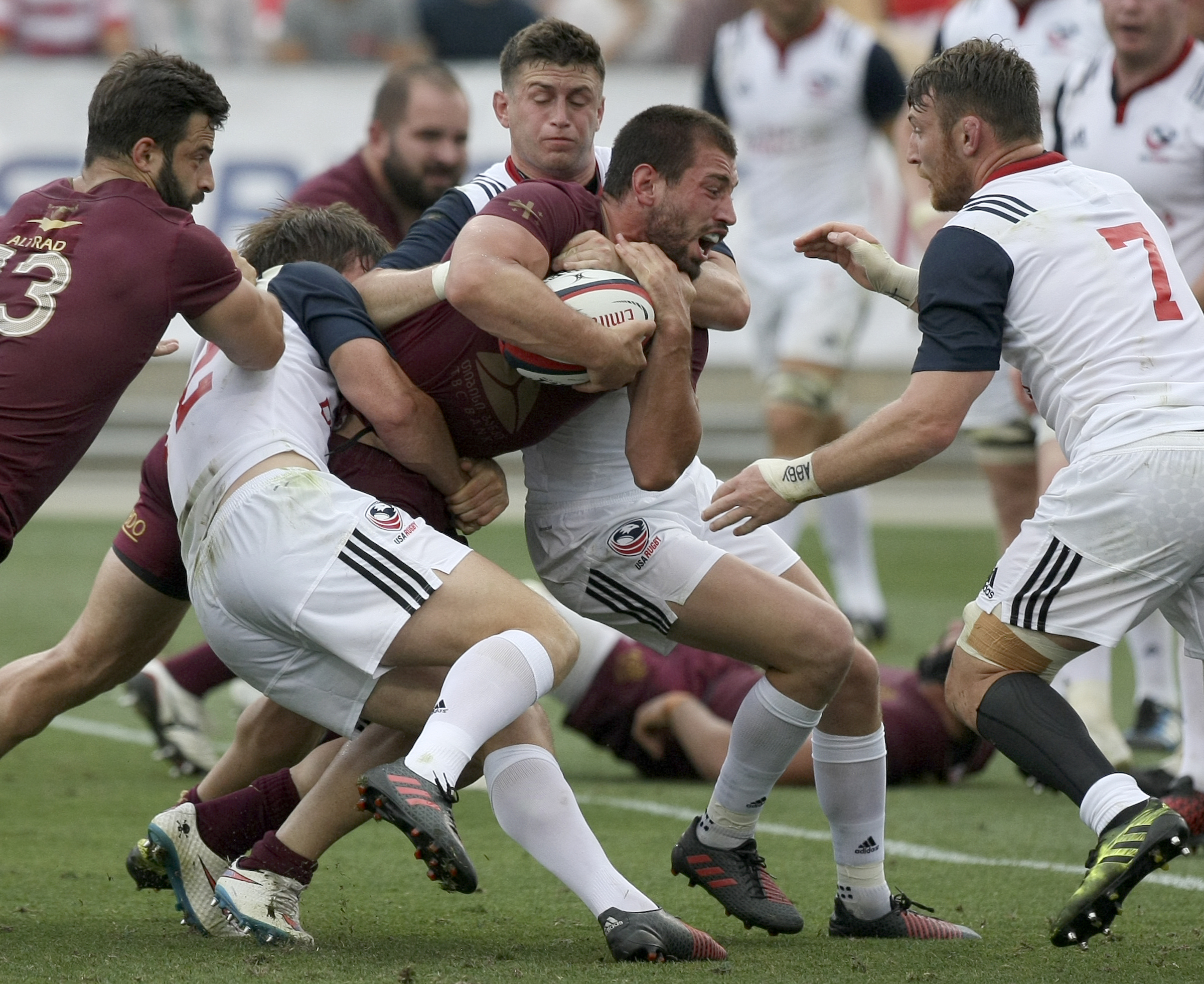 USA's AJ MacGinty (12) and Will Magie tackle Georgia captain Merab Sharikadze (12) during an international rugby test match at Kennesaw State University's Fifth Third Bank Stadium on Saturday, June 17, in Kennesaw, Ga.