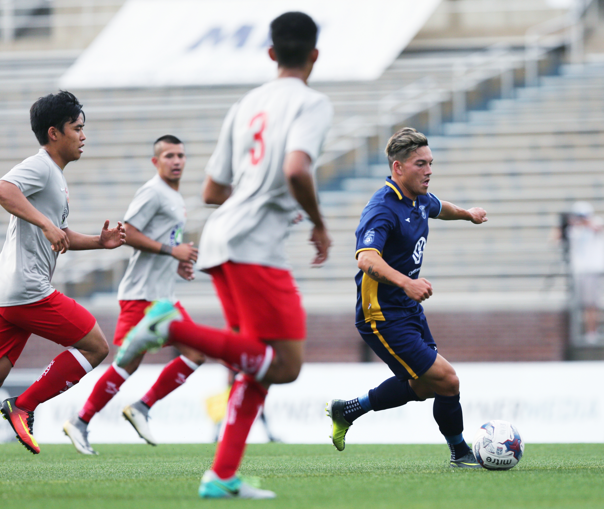 Chattanooga Football Club's John Carrier (7) dribbles the ball downfield as Birmingham Hammers players chase after him Tuesday, June 20, 2017, during the CFC boys game against the Birmingham Hammers at Finley Stadium in Chattanooga, Tenn. CFC won 5-0.