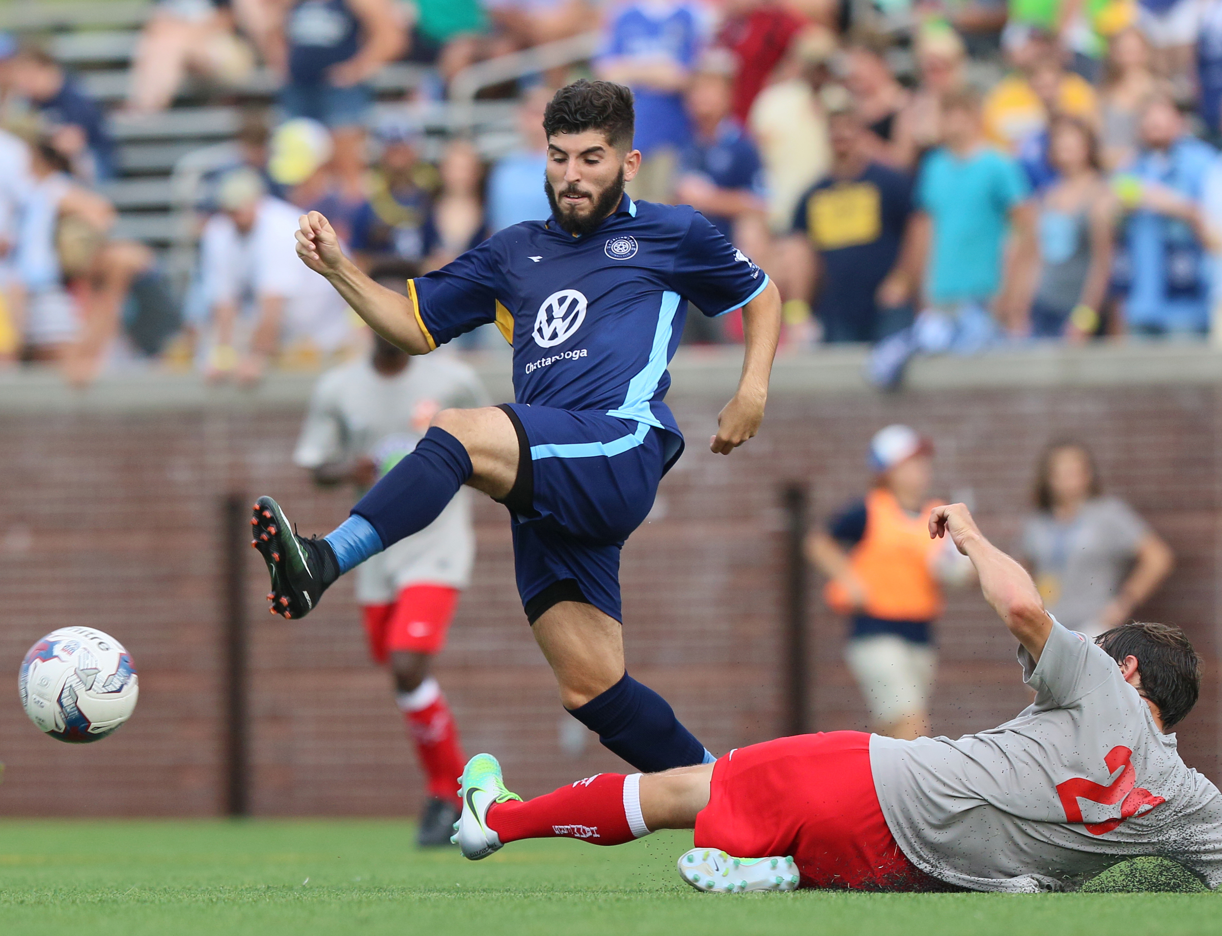 Chattanooga Football Club's Felipe Oliveira (20) passes the ball as Birmingham Hammers' Robert Stroupe (28) slide tackles him Tuesday, June 20, 2017, during the CFC boys game against the Birmingham Hammers at Finley Stadium in Chattanooga, Tenn. CFC won 5-0.