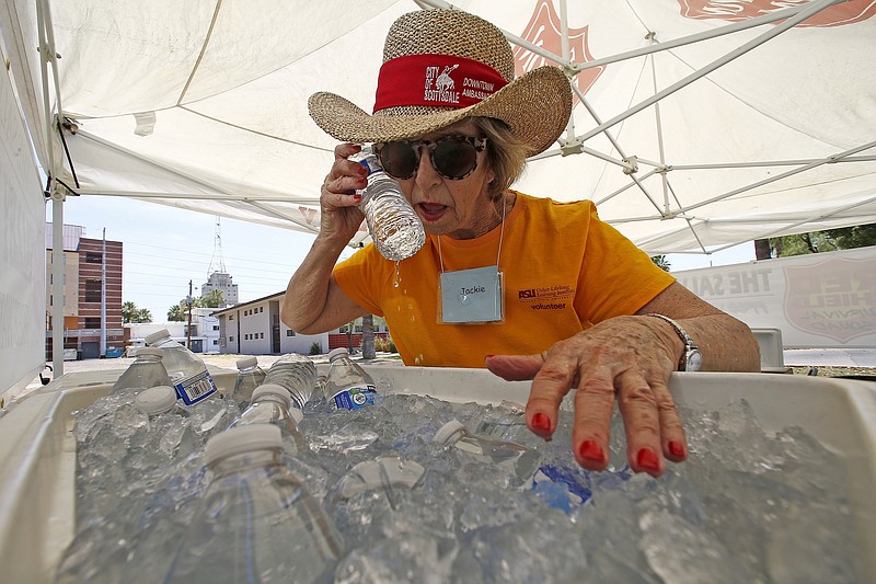 
              Salvation Army volunteer Jackie Rifkin tries to keep cool at she works at a special Salvation Army hydration station to help people try to keep hydrated and stay cool as temperatures climb to near-record highs, Monday, June 19, 2017, in Phoenix. (AP Photo/Ross D. Franklin)
            