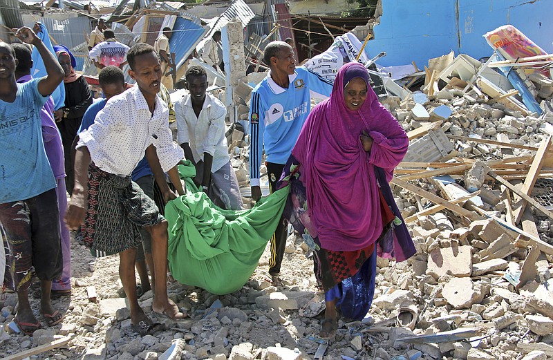 
              Somalis carry away the body of a civilian who was killed in a car bomb attack in Mogadishu, Somalia Tuesday, June 20, 2017. A number of people are dead after a suicide car bomber in a vehicle posing as a milk delivery van detonated at a district headquarters in Somalia's capital, police said Tuesday. (AP Photo/Farah Abdi Warsameh)
            