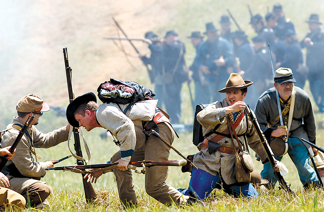 Confederate re-enactors fall back as Union troops advance during the Battle of Resaca Reenactment in Georgia. The annual re-enactment showcases a battle fought in May 1864 as part of General Sherman's Atlanta Campaign during the Civil War.