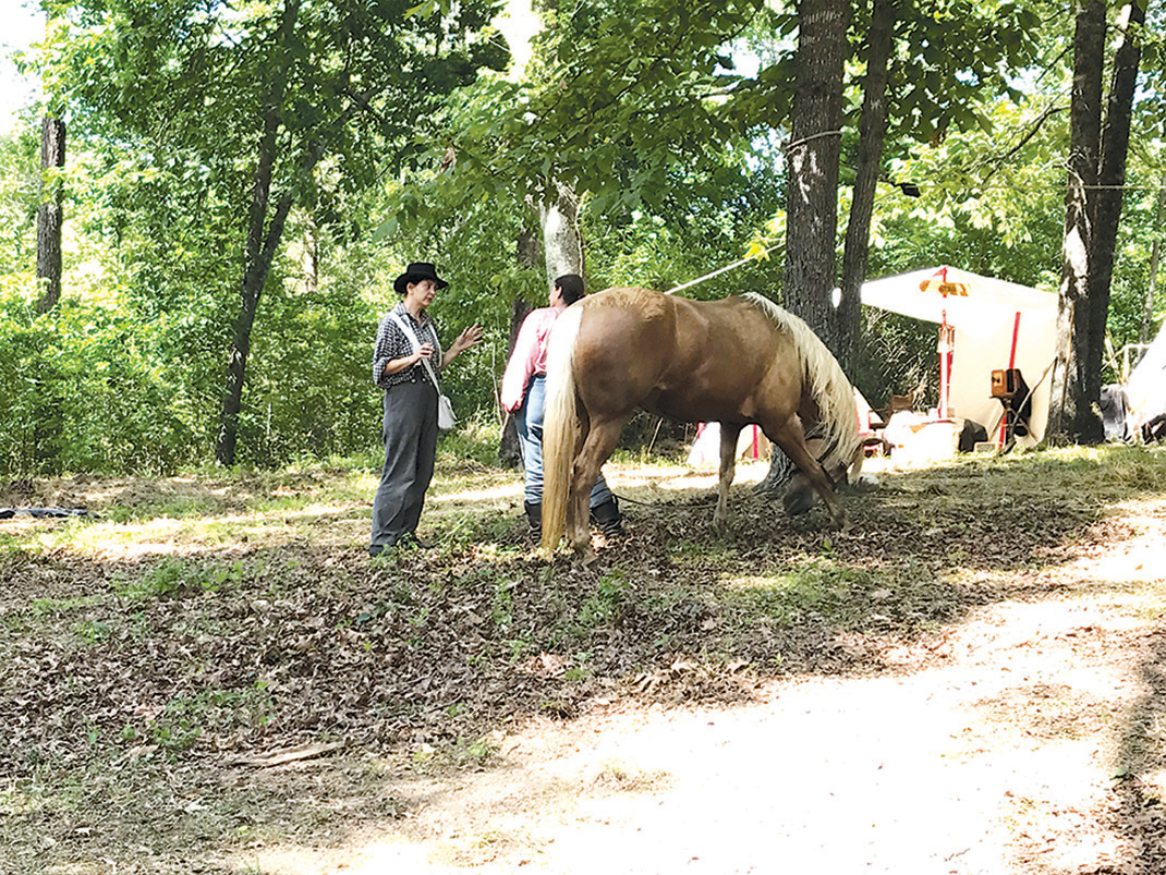 Soldiers talk next to a horse tied up in camp to rest following the re-enactment of the Battle of Resaca.