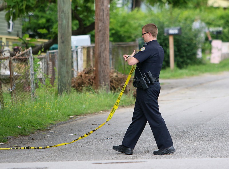 A Chattanooga Police Officer wraps up crime scene tape that blocked off a portion of Stanfiel Street Wednesday, June 21, 2017, in Chattanooga, Tenn. Police were investigating a shooting that happened in the 1700 block of Stanfiel Street Wednesday afternoon. 