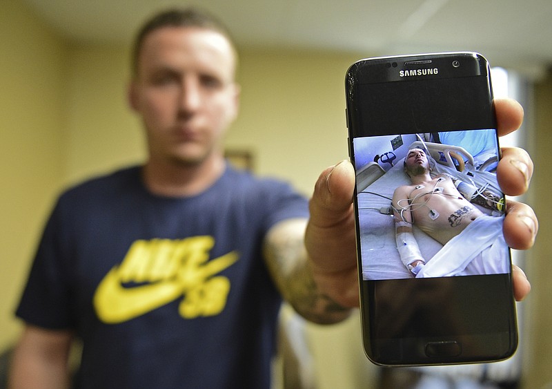 
              Paul Wright shows a picture of himself in the hospital after a near fatal overdose in 2015, Thursday, June 15, 2017, at the Neil Kennedy Recovery Clinic in Youngstown, Ohio. Republican efforts to roll back “Obamacare” are colliding with the opioid epidemic. Cutbacks would hit hard in states that are deeply affected by the addiction crisis and struggling to turn the corner. The issue is Medicaid, expanded under former President Barack Obama. Data show that Medicaid expansion is paying for a large share of treatment costs in hard hit states. (AP Photo/David Dermer)
            