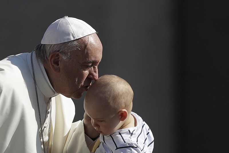 
              Pope Francis kisses a child as he arrives for his weekly general audience in St. Peter's Square at the Vatican, Wednesday, June 21, 2017. (AP Photo/Alessandra Tarantino)
            